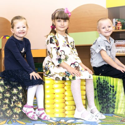 children on corn, pineapple and kiwi cube seats